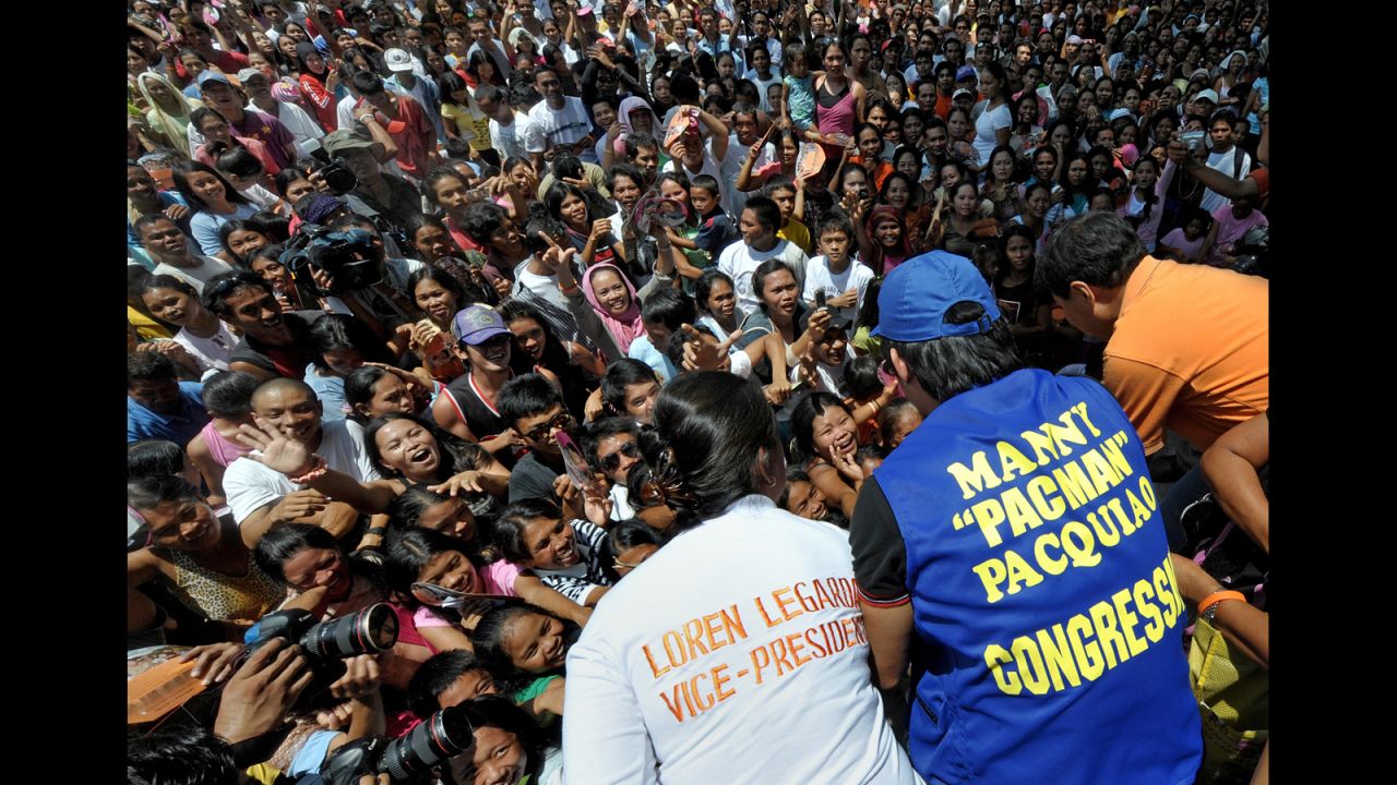 Pacquiao, center, greets supporters with presidential candidate Manny Villar, right, and vice-presidential candidate Loren Legarda, left, as he starts his campaign for Congress in March 2010. 