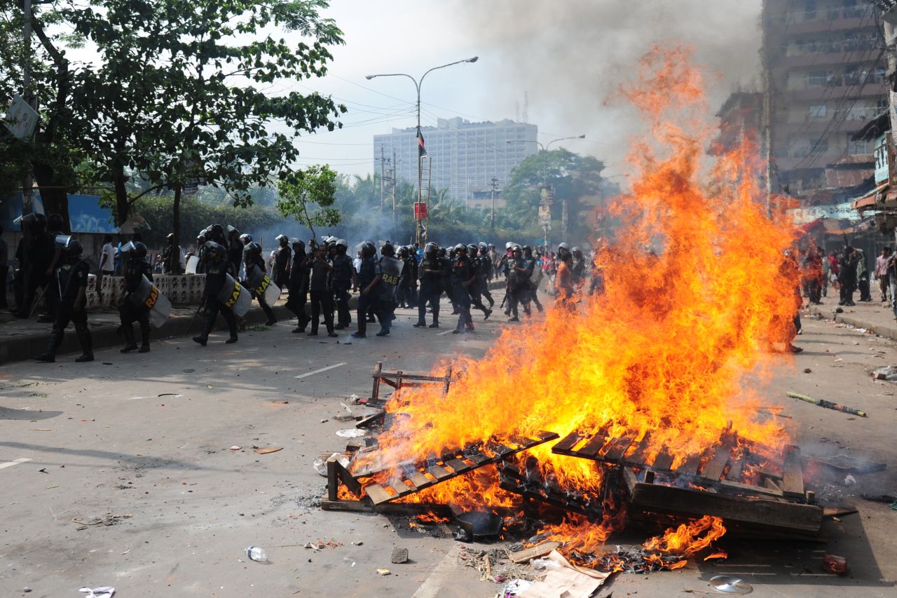Police walk past a fire set by Islamist protesters on May 5 during clashes with police.