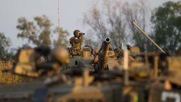 An Israeli soldier looks at his binoculars from the top of his Merkava tank during a drill near the border with Syria at the Israeli-annexed Golan Heights on May 6, 2013. 
