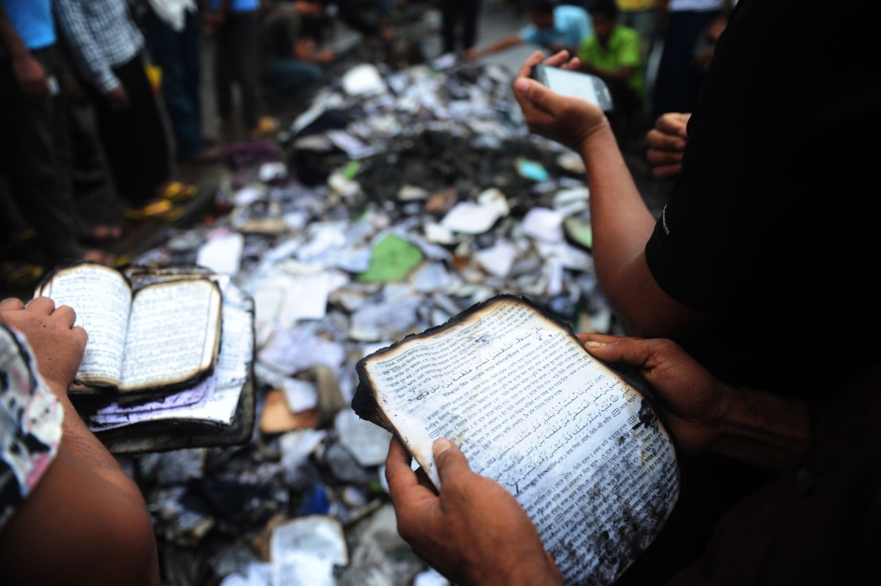 Bangladeshi people look at burned religious literature, including the Quran, near the national mosque Baitul Mukarram in Dhaka on May 6.