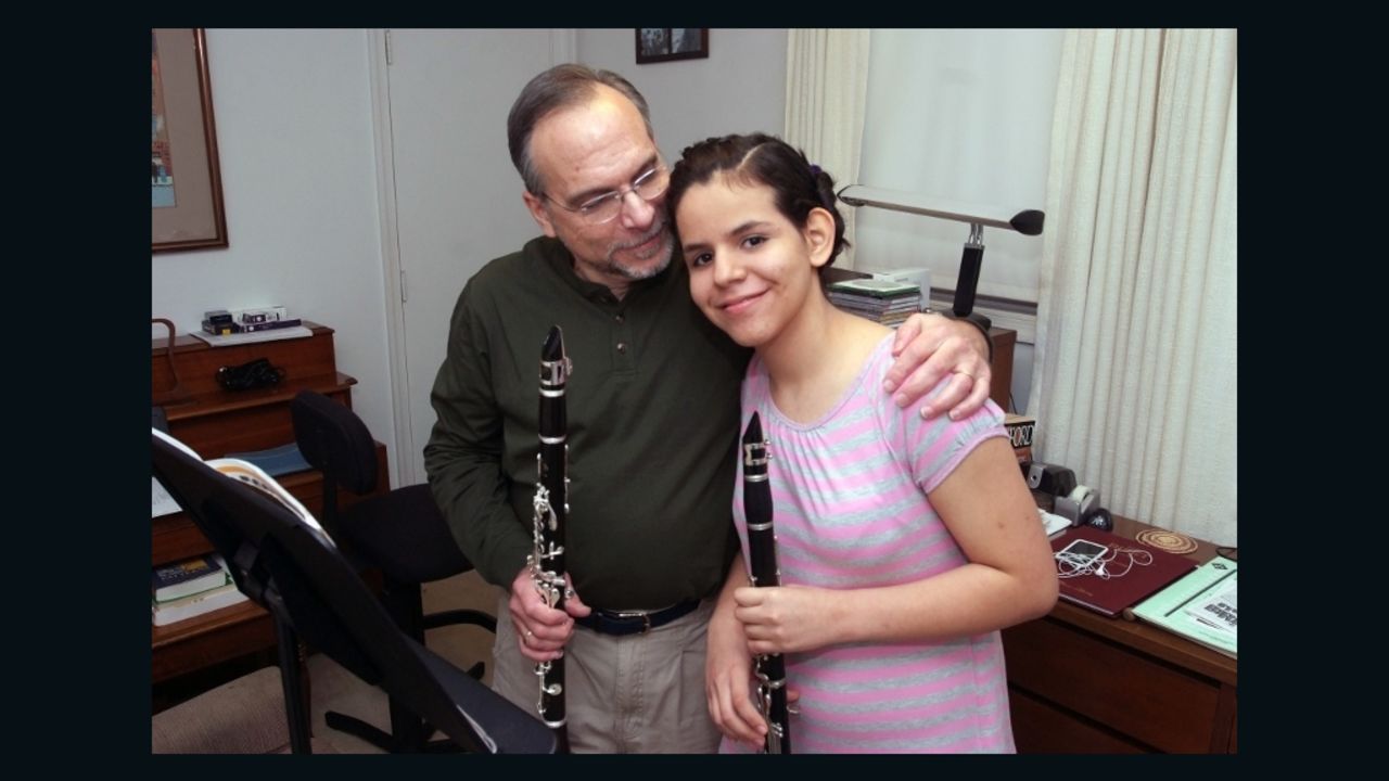 13-year-old Mano Kolman and her father, Barry, prepare to play a clarinet duet together.