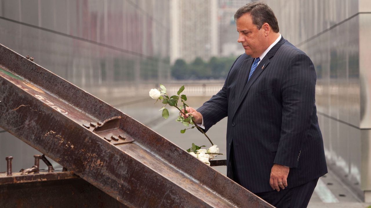 Christie lays a white rose on wreckage pulled from ground zero during the dedication for the Empty Sky Memorial at Liberty State Park on September 10, 2011, in Jersey City, New Jersey.