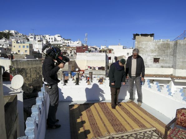 Bourdain looks at a Moroccan rug with the owner of Boutique Majid, Abedelmajid Rais El Fenni.