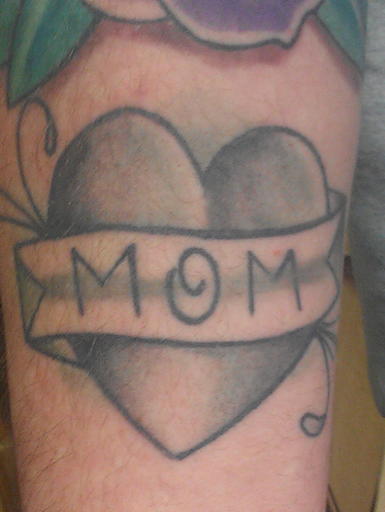 Emily's husband Robert Kirouac also has a mom tattoo on his arm. His mom said that if he was going to get a tattoo, <a href="http://ireport.cnn.com/docs/DOC-967021">he had to get a "mom" one</a>. Additionally, it had to look like singer Adam Levine's mom tattoo, because "she watches him on 'The Voice' and she thinks he's hot," said Kirouac. This was the result -- compare it with Levine's in the next frame. "I proudly wear my mom tat because it is exactly what she wanted, and I love to keep my mom happy," said Kirouac.