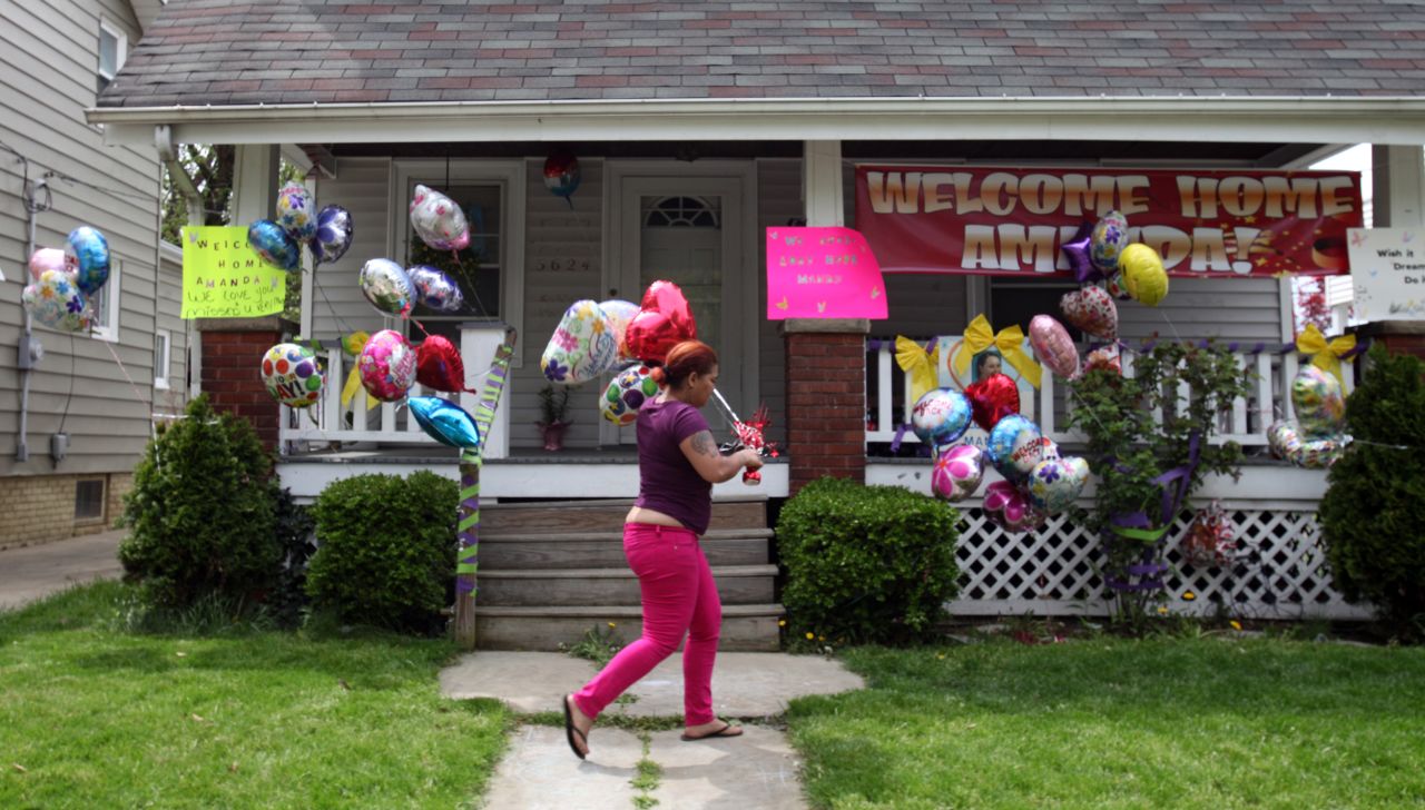 A relative of DeJesus brings balloons to the home of Amanda Berry's sister in Cleveland on May 7.