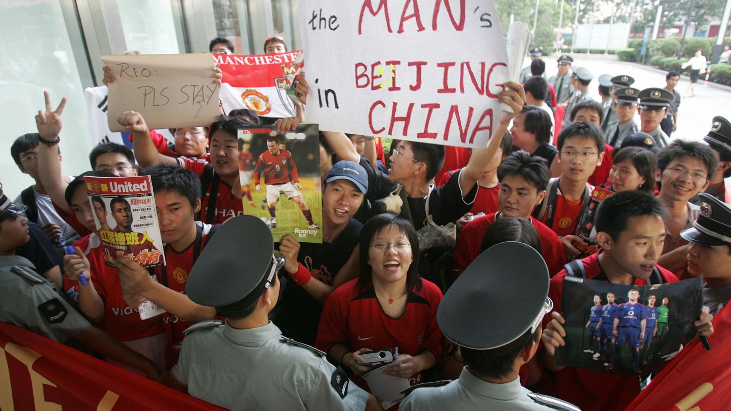 Chinese soccer fans are held back by security guards outside Manchester United's team hotel in Beijing in 2005.