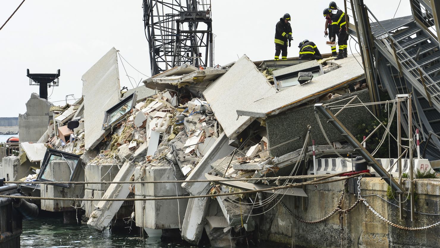 Rescue workers inspect the scene of a damaged control tower in the port of Genoa on May 8, 2013.