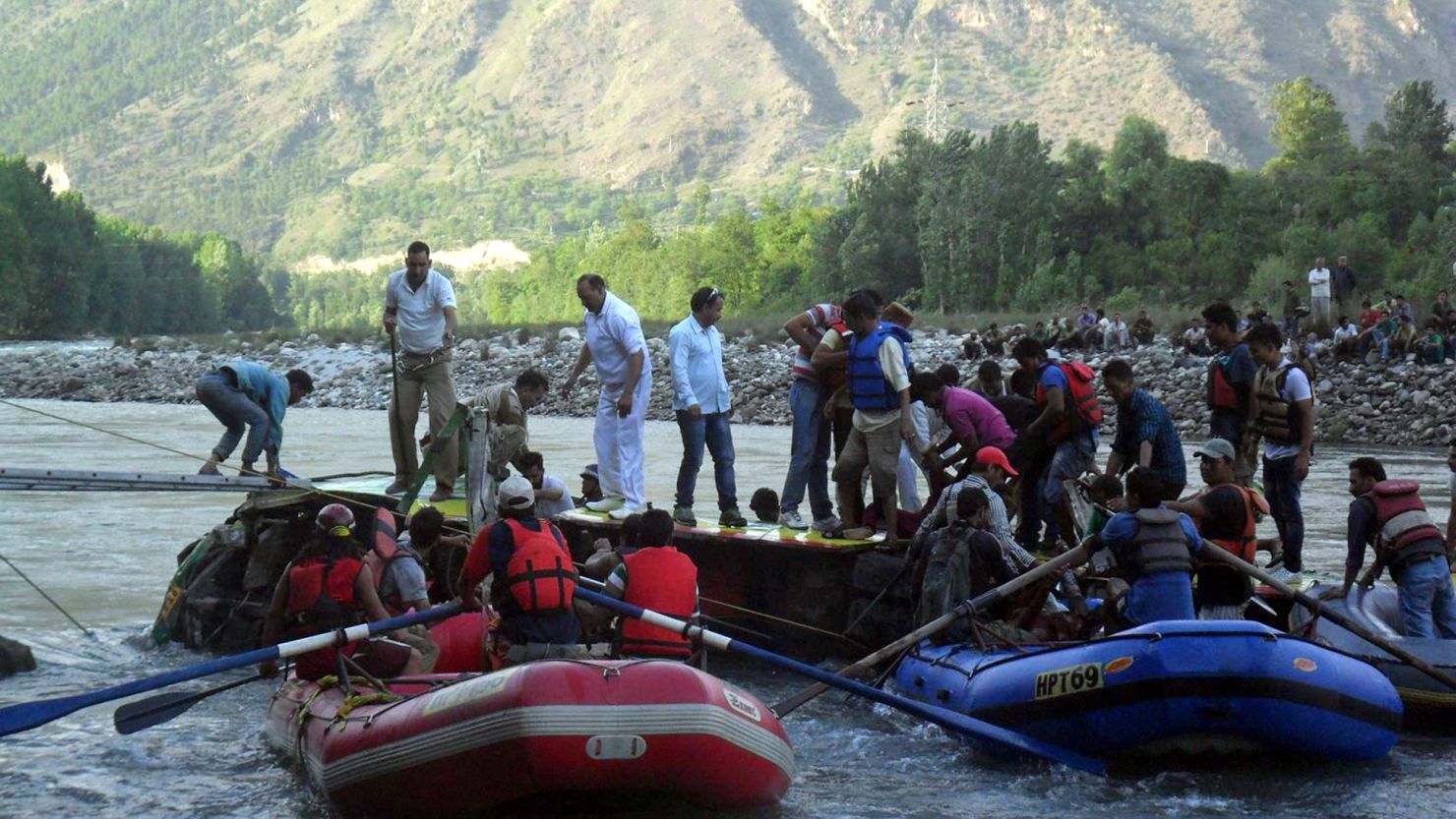 Volunteers and police try to reach victims inside the partially submerged bus in India's Himachal Pradesh state, on May 8, 2013. 