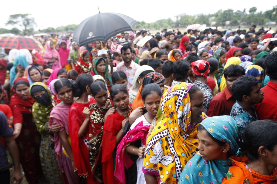 Garment workers who survived the building collapse line up to collect their salaries in Savar on May 8.
