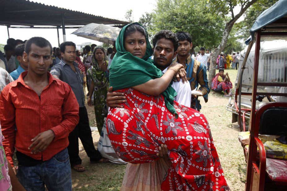 An injured worker who survived the building collapse is carried by her husband to collect her wages in Savar near Dhaka, Bangladesh, on Wednesday, May 8.