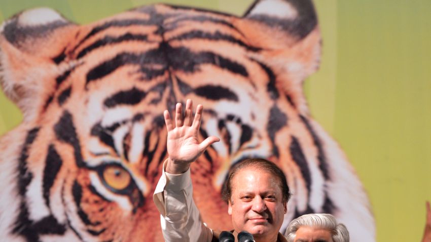 Former Pakistani Prime Minister Nawaz Sharif (C) waves as he addresses his supporters during an election campaign meeting in Islamabad on May 5, 2013. A roadside bomb exploded at an election rally in southwest Pakistan on May 5 killing two people, officials said as violence continued ahead of historic polls on Saturday. Campaigning has been marred by Taliban threats and attacks, which have killed 69 people since April 11, according to an AFP tally. Pakistan will elect its new government for the next five years in polls on May 11. The election of the national and four provincial assemblies will mark the first time a civilian government has completed a full term and handed over to another, in a country that has been ruled by the military for half its existence. AFP PHOTO / AAMIR QURESHI