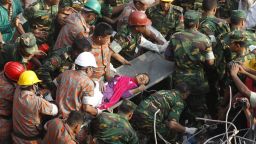 Rescue workers carry Reshma Begum, 19, to safety on Friday, May 10, a day after her discovery alive amid the wreckage of a building that had entombed her since it collapsed on April 24, in Dhaka, Bangladesh. At least 1,127 people have been confirmed dead from the garment factory building collapse.