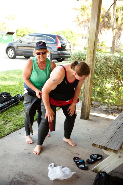 Miller is amused as she struggles to put on her wetsuit for the first time. 