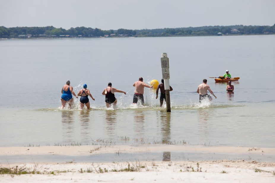Members of the "6-Pack" practice racing into the water before their first ocean swim. 