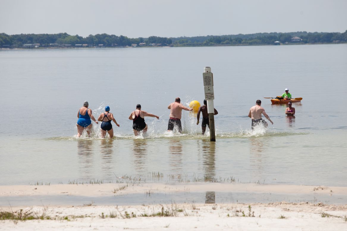 Members of the "6-Pack" practice racing into the water before their first ocean swim. 
