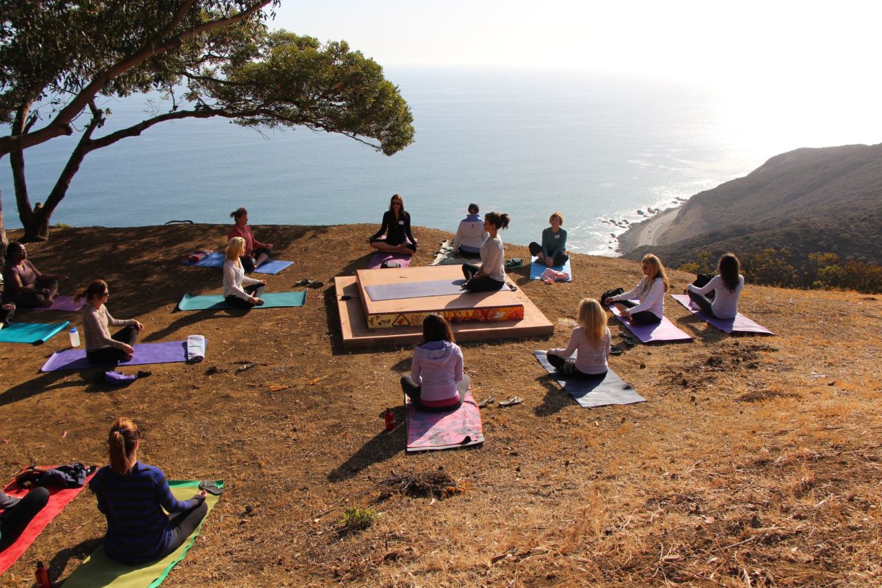 The day begins with a morning yoga session outside.