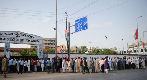 Pakistani voters queue for their turn to cast their ballots outside a polling station in Karachi on May 11, 2013. 