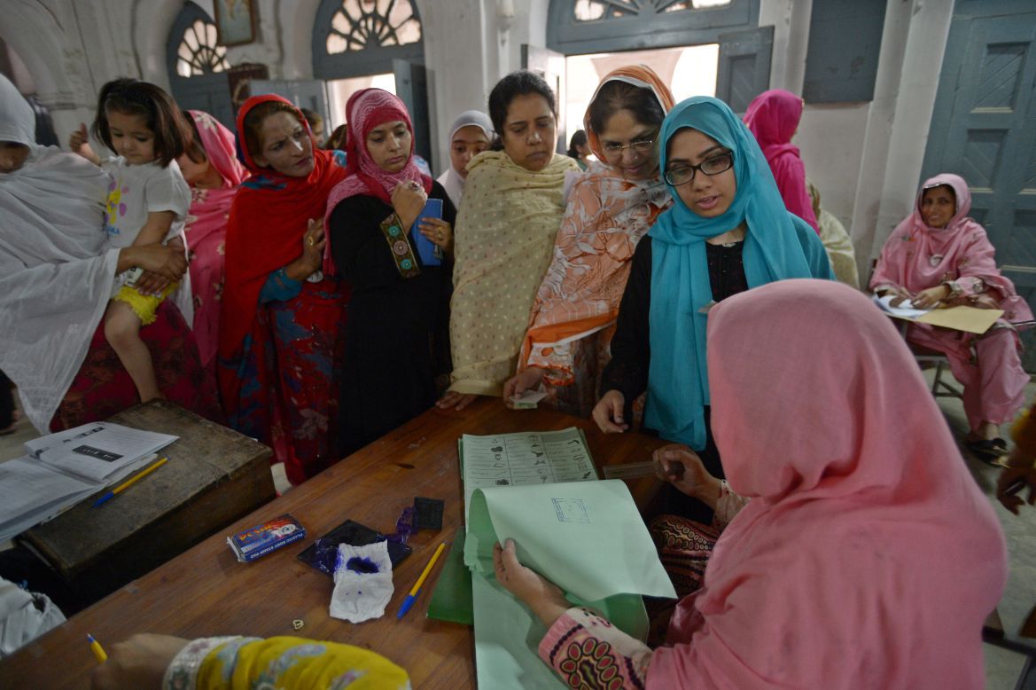 Voters in Rawalpindi gather around an election presiding officer to cast their ballots on May 11, 2013. 