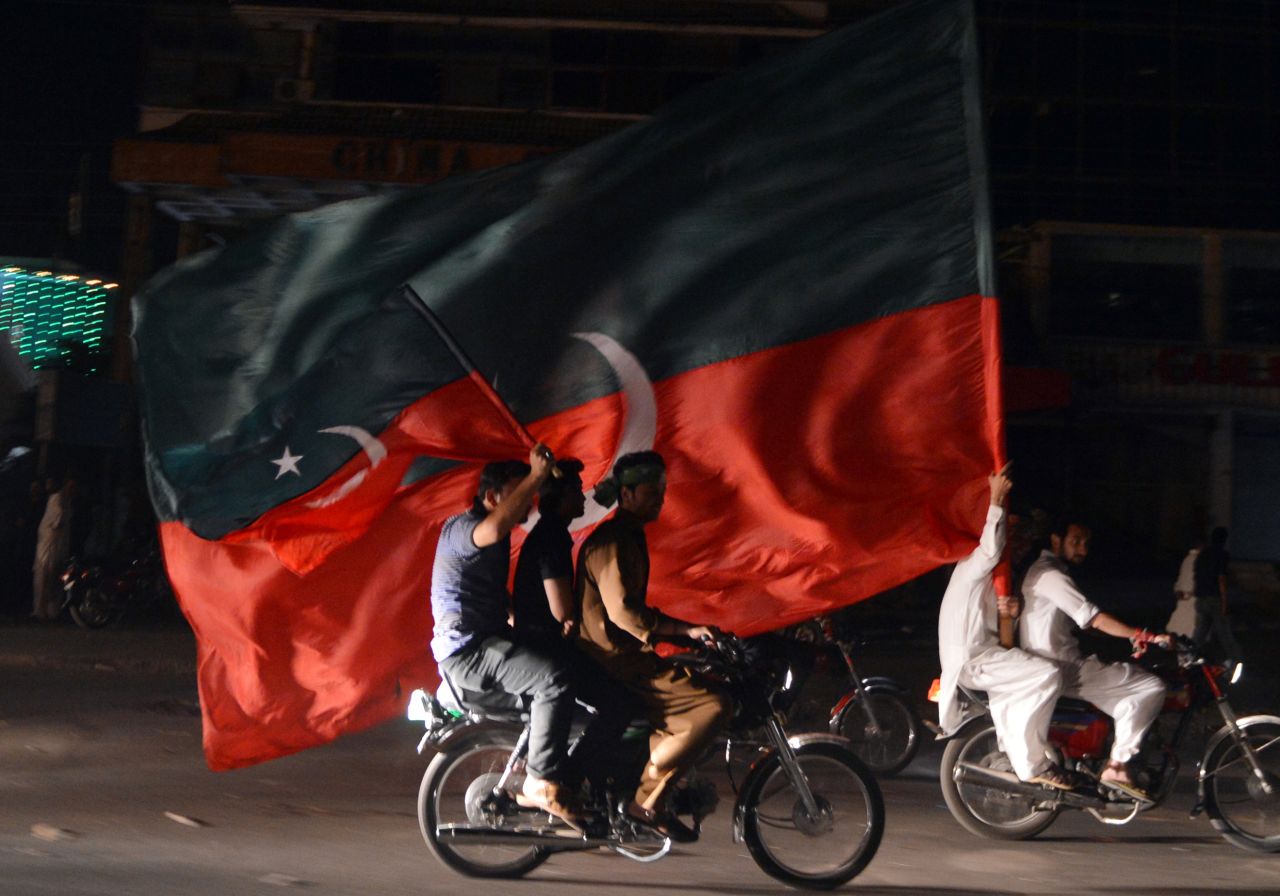 Khan supporters carry their party flags in a rally in Rawalpindi on May 12.