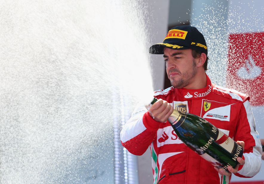 Fernando Alonso celebrates on the podium after winning the Spanish Grand Prix.