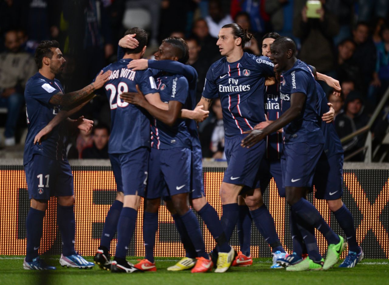 Jeremy Menez is mobbed by his teammates after scoring the winning goal at Lyon that secured Paris Saint-Germain's first French title since 1994. 