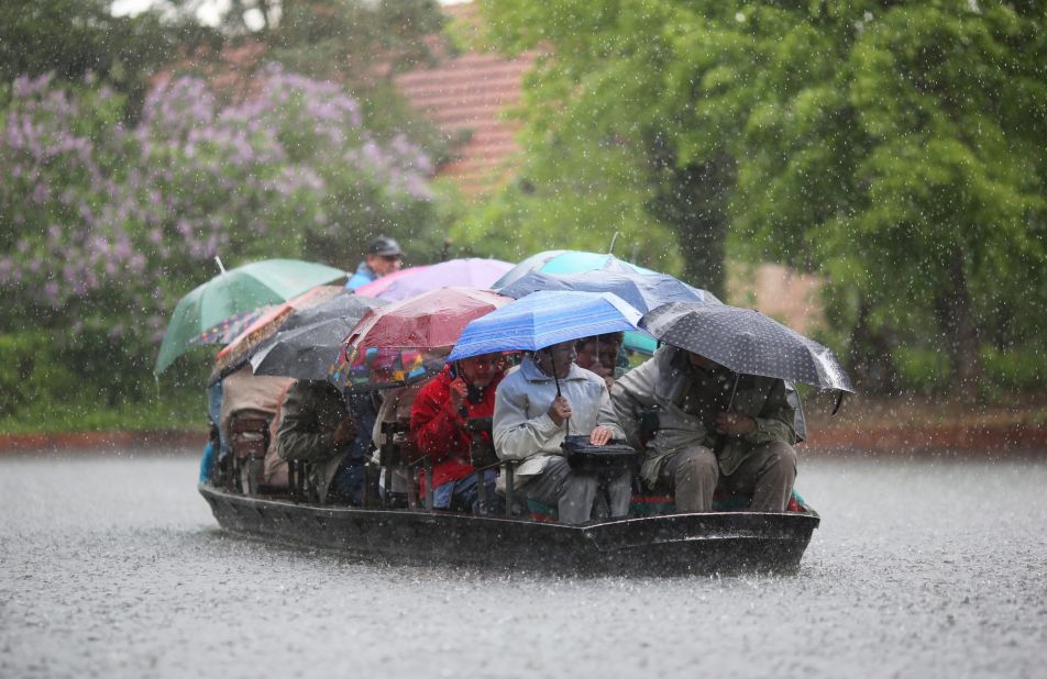 People take shelter under umbrellas during a boat ride in heavy rain on the Spreewald Canals near Luebbenau, Germany, on Sunday, May 12.