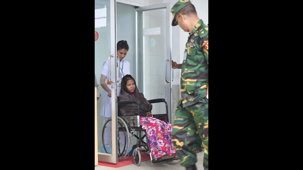 A nurse helps Begum through a door as she attends a media conference at the Savar Combined Military Hospital in Dhaka on May 13.