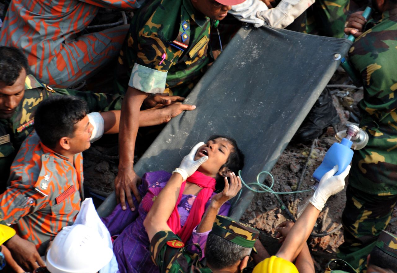 Rescuers workers administer first aid as they carry Begum from the rubble on May 10 in Dhaka.
