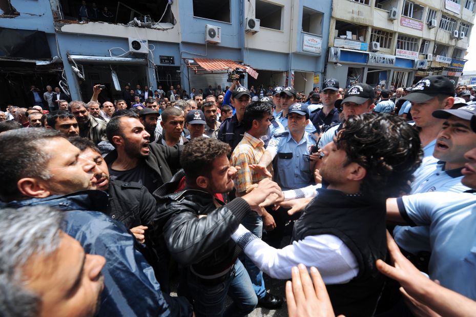 People try to stop relatives of a victim of the bombings as they argue with police officers on May 13 in Reyhanli. The bombing left at least 47 dead and around 100 injured after two explosive-laden cars exploded in the street.