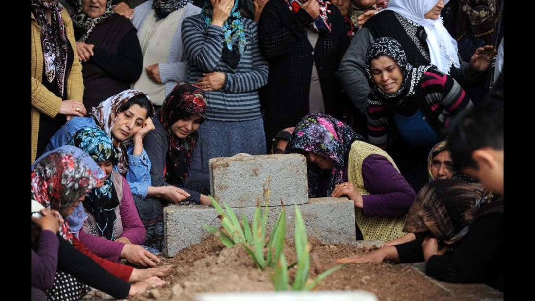 Relatives mourn at the grave of a bombing victim on May 12.  Residents of Reyhanli called on Turkey's government to step down, alleging that it has gotten their country too involved Syria's troubles.