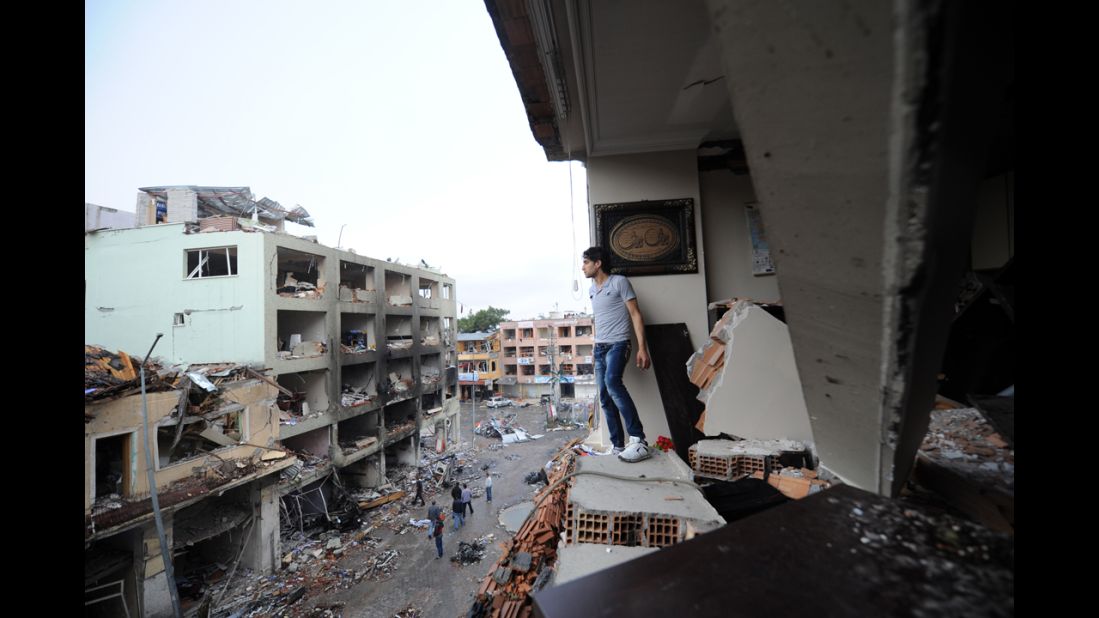 A man stands in a damaged building on May 12 overlooking the scene of the bombing.