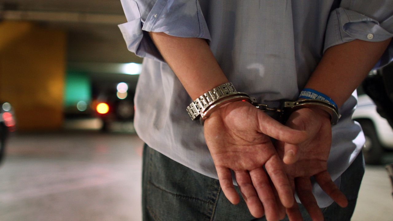 MIAMI - JULY 04:  A driver who failed a field sobriety test at a DUI traffic checkpoint stands in handcuffs waiting to be processed June 4, 2007 in Miami, Florida. Several law enforcement agencies were conducting the checkpoint and conducting saturation patrols to help save lives during the 4th of July holiday. The National Safety Council has rated the  July 4th holdiay as one of most lethal holidays for drivers, with alcohol factoring into nearly half of all motor vehicle deaths.  (Photo by Joe Raedle/Getty Images) 