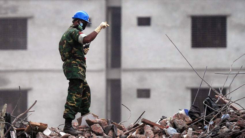 A Bangladeshi Army official gestures as he guides an excavator operator to removes debris as they continue the second phase of the rescue operation using heavy equipment after an eight-storey building collapsed in Savar, on the outskirts of Dhaka, on May 11, 2013. Bangladeshi doctors treating a 'miracle' survivor pulled from ruins of a collapsed building after 17 days said that she was doing 'great' and had been reunited with her family. Reshma, 18, a seamstress dug out from the rubble of the garment factory complex, 'never gave up hope' she would be rescued from the ruins of one of the world's worst industrial disasters, army doctor Fakrul Islam told AFP. AFP PHOTO/Munir uz ZAMAN (Photo credit should read MUNIR UZ ZAMAN/AFP/Getty Images)