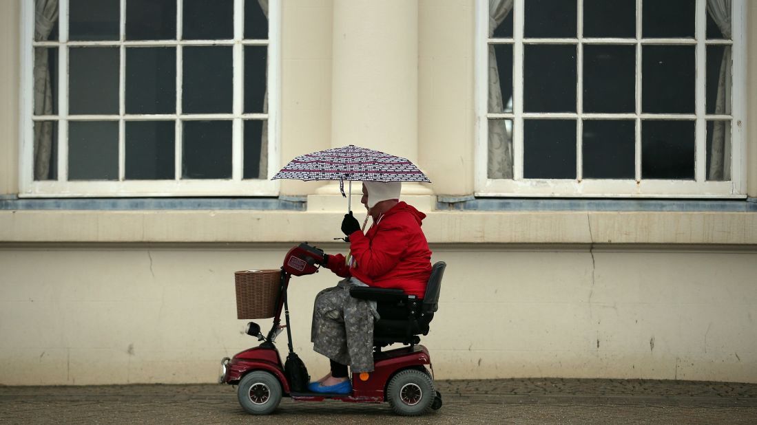 A woman passes along the seafront as the rain falls in Weston-Super-Mare, England, on Tuesday, May 14. 