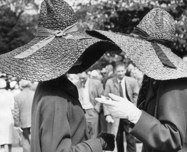 Hat to hat chat....two women in straw hats chat during a visit to the 1964 Chelsea Flower Show