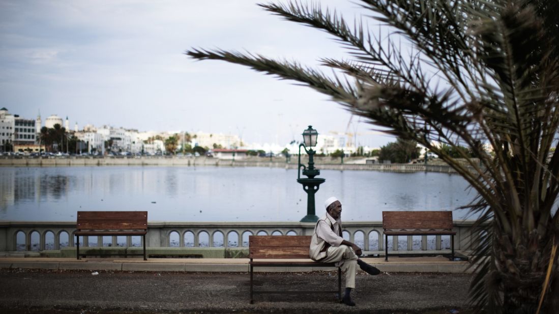 A man sits on a bench next to an artificial lake between the waterfront and Tripoli's iconic Martyrs' Square, formerly Green Square, on October 5, 2011.