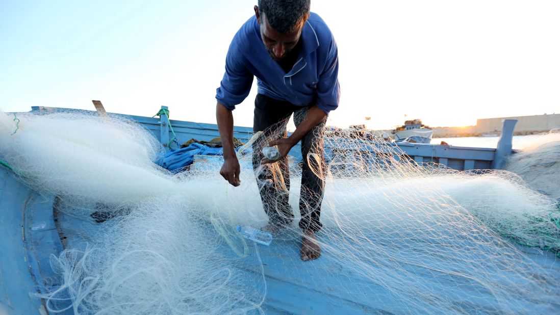 A man inspects his fishing net in the port of Tripoli on November 3.