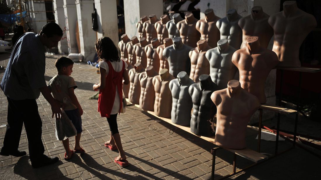Children walk past a stall at the Rashid Street market in the center of Tripoli on August 29, 2011.