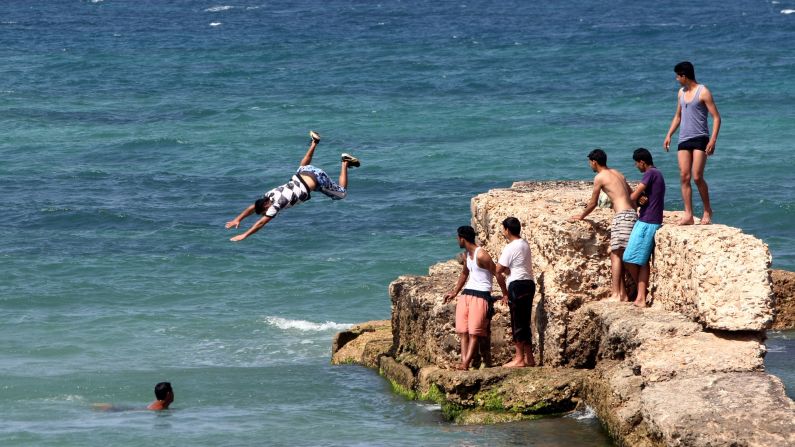 A young man jumps into the waters of the Mediterranean Sea off the coast of Tripoli on April 30, 2012.