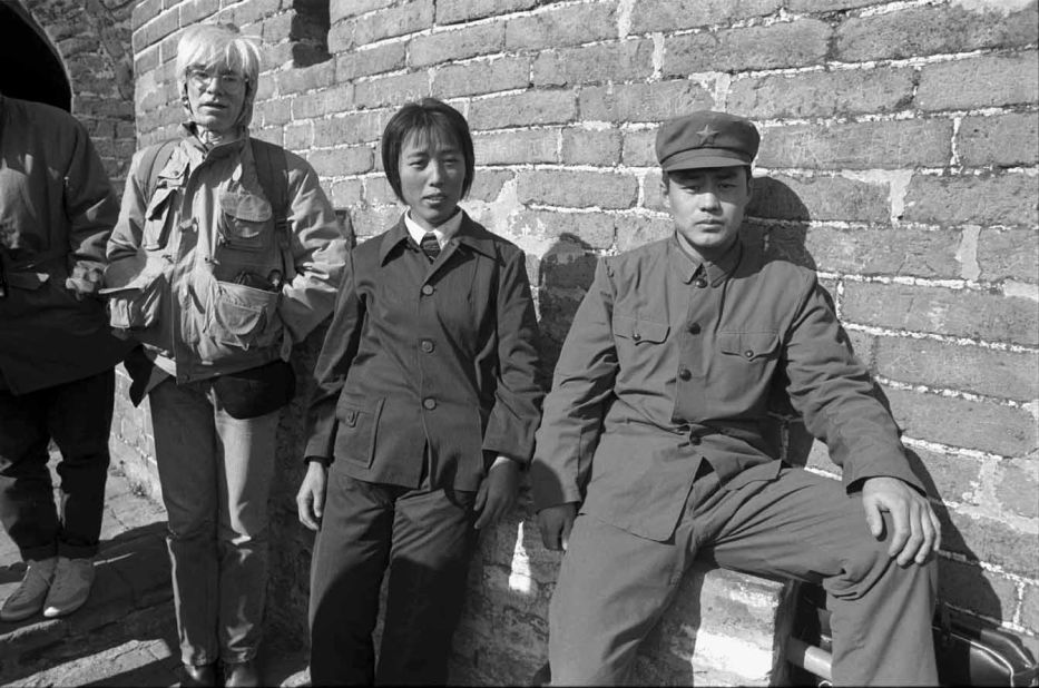 Warhol stands by Chinese citizens on the Great Wall of China. 