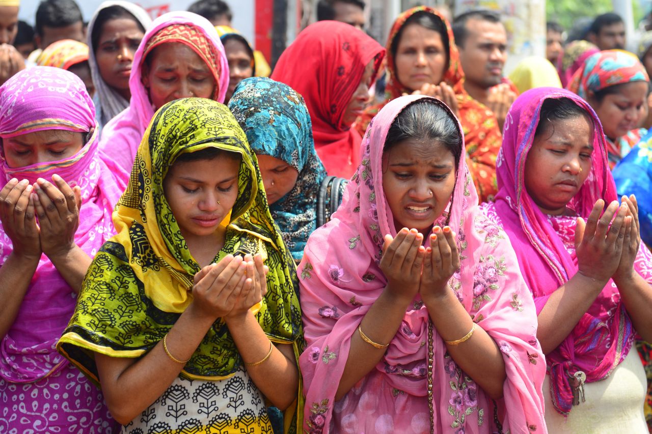 Relatives of missing garment workers offer prayers in front of the rubble on May 14 in Savar.