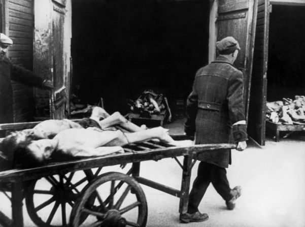 The conditions in the overcrowded ghetto caused thousands of deaths. In this picture from 1942, a man carries away bodies of people who died of hunger in the streets.