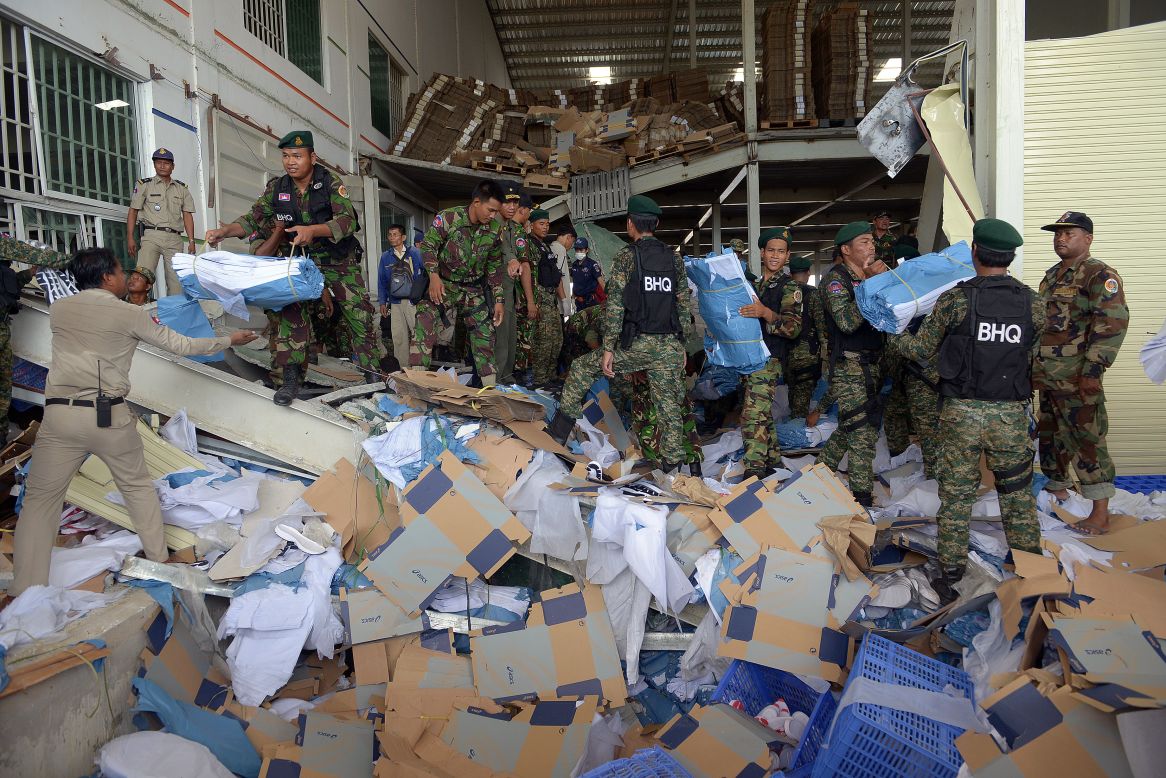 Cambodian soldiers move debris after the collapse. Shoes made by the Japanese sports apparel company Asics were in evidence at the factory.
