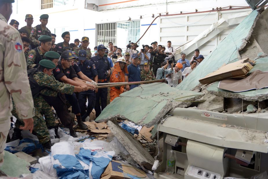 Cambodian soldiers try to move concrete after a walkway collapsed in a shoe factory warehouse in Kampong Speu province, west of Phnom Penh, on Thursday, May 16. Two people died and six were injured after the raised concrete walkway fell.