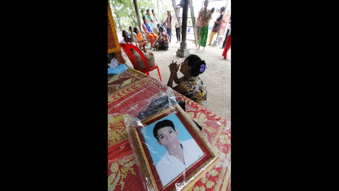 Kim Leap grieves next to a portrait of her son Rim Saroeun. Saroun, 22, was one of eight family members who worked at the factory, a relative said. 