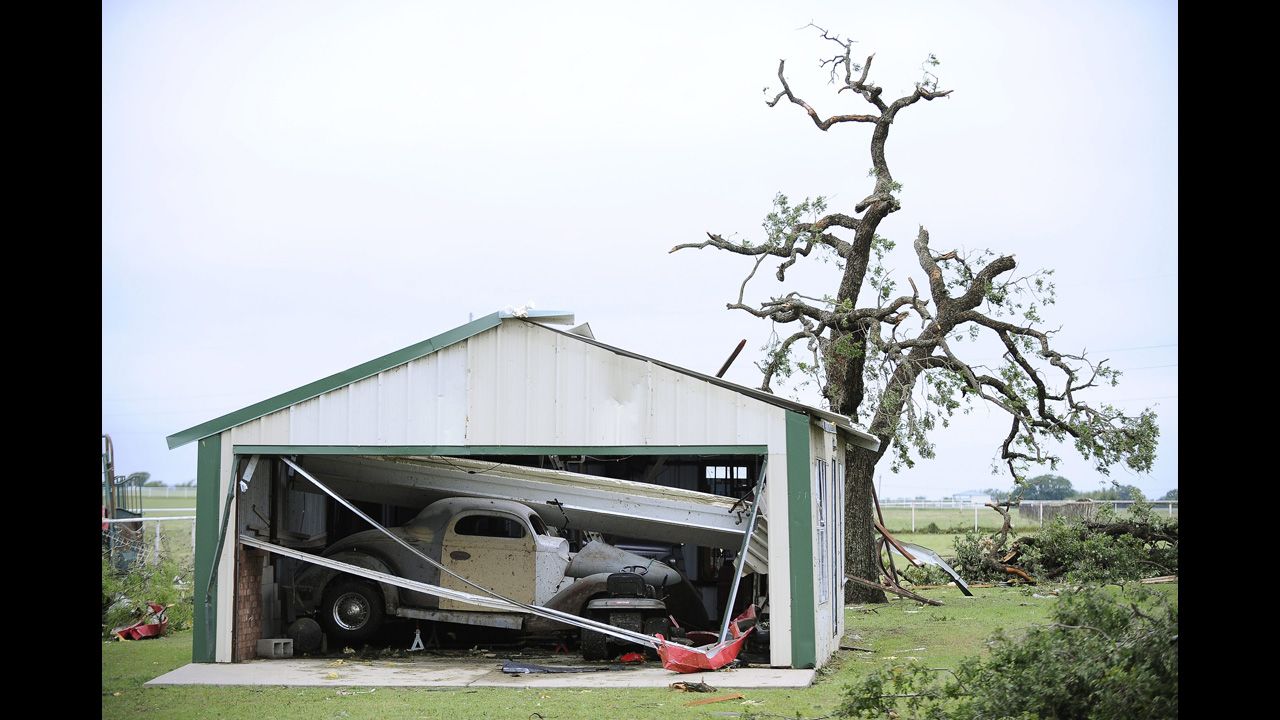 An antique car sits in a collapsed garage on May 16 in Granbury.