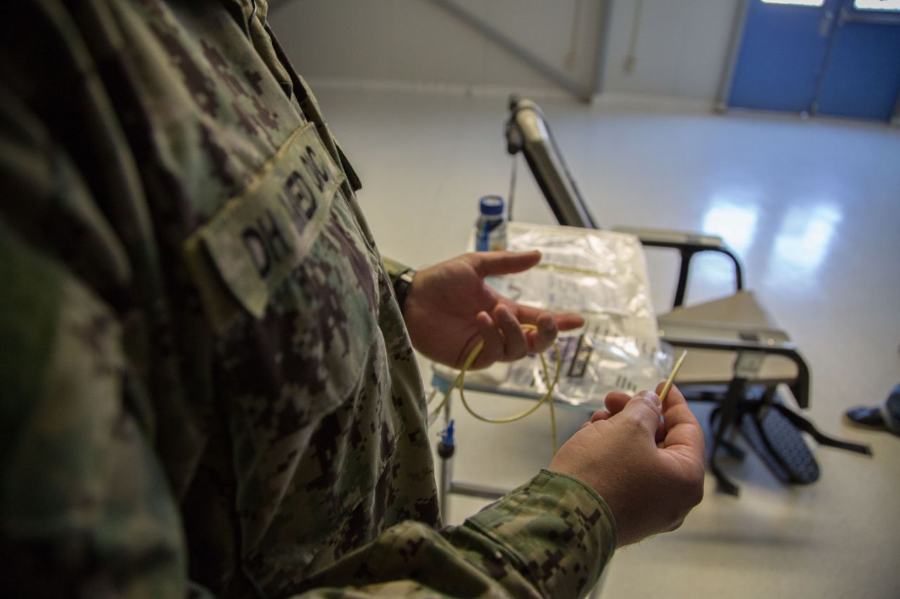 A Detainee Hospital Medical Officer holds a feeding tube as he explains how the procedure is carried out.