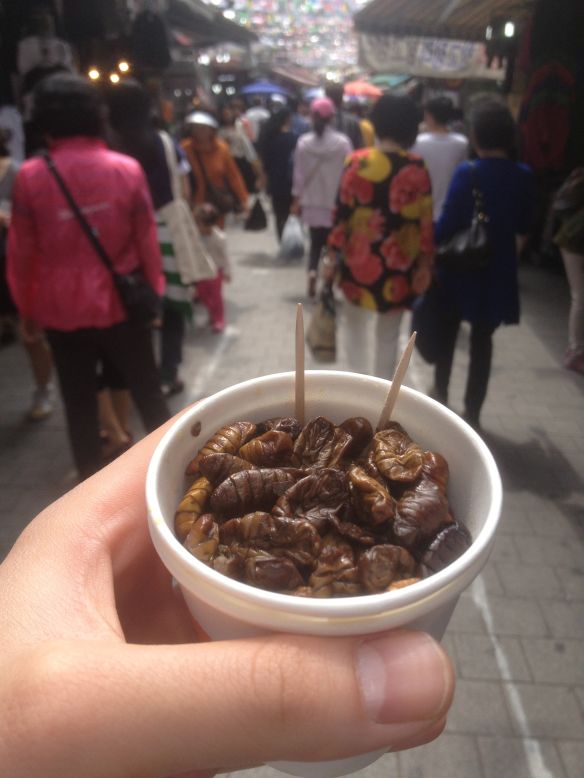 La pupa del gusano de seda hervido es vendida en pequeños vasos de papel en mercados coreanos.