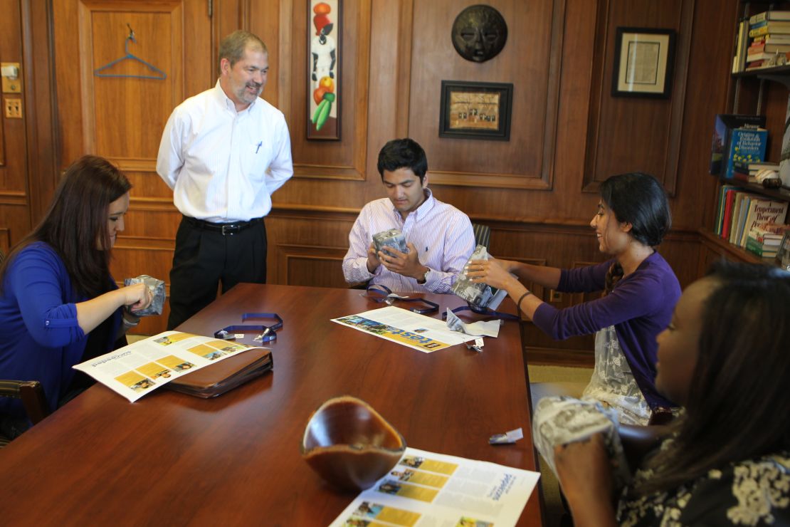 Berry President Steve Briggs presents graduating refugee students with silver engraved cups.