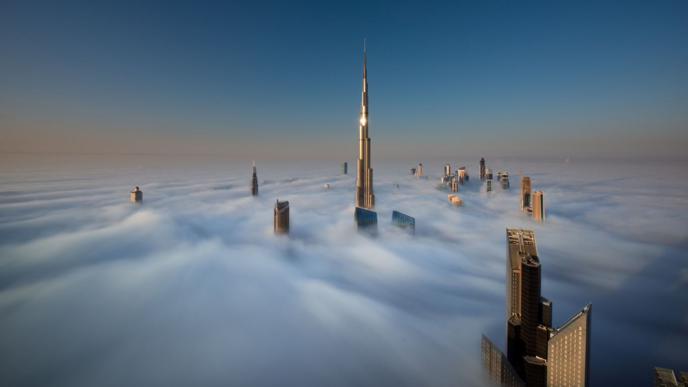 The windows of the Burj Khalifa catch a glint of sunlight as the skyscrapers of Dubai stand high above the clouds in this image taken from the 79th floor of the Index Tower.